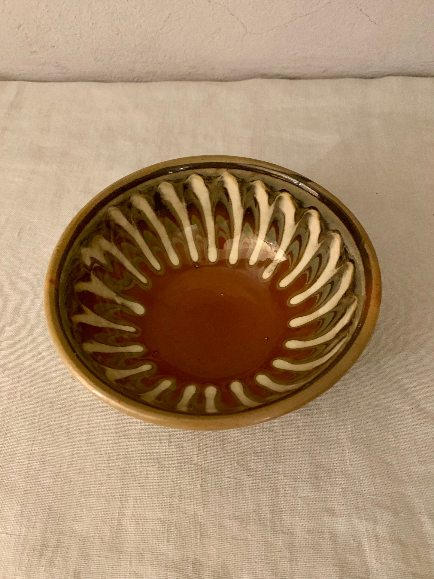 Vintage clay bowl with beautiful running glaze.